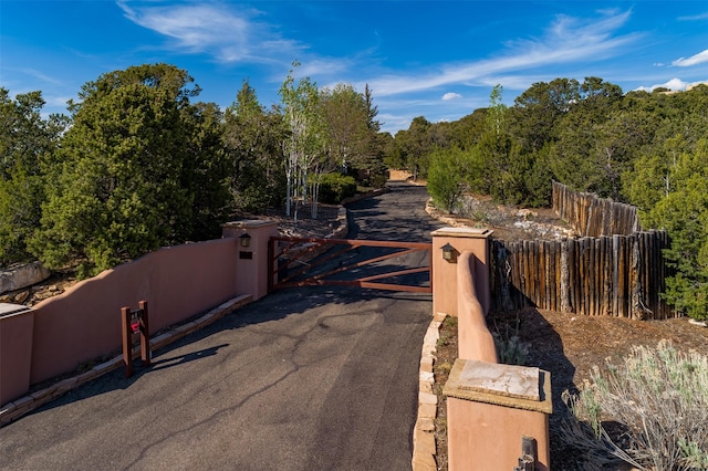 1050 Sierra Del Norte, Santa Fe, NM 87501 - view of road featuring a gate and a wooded view