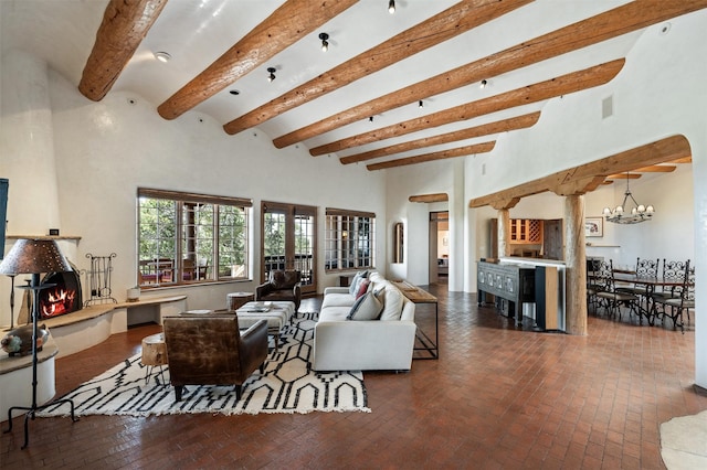 1050 Sierra Del Norte, Santa Fe, NM 87501 - living area featuring brick floors, beamed ceiling, a large fireplace, decorative columns, and a towering ceiling