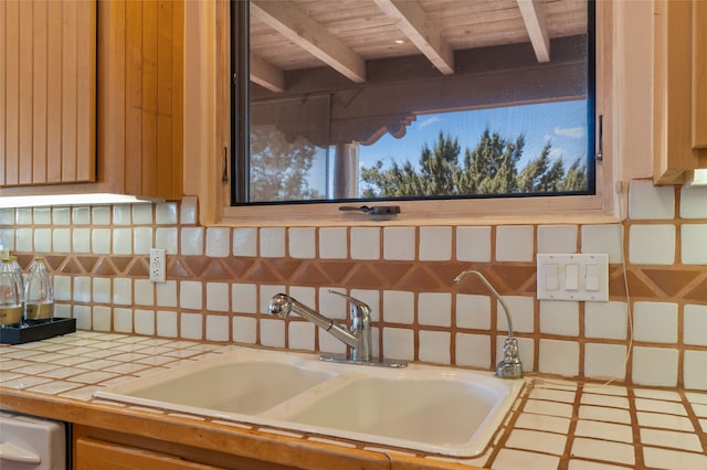 28 Camino Caballos, Lamy, NM 87540 - kitchen featuring tile countertops, a sink, backsplash, and wood ceiling with exposed beams