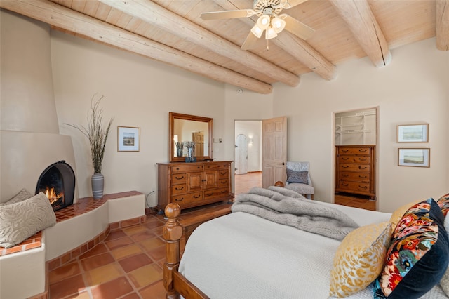 28 Camino Caballos, Lamy, NM 87540 - tiled bedroom with wooden ceiling with exposed beams and a fireplace