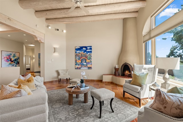 28 Camino Caballos, Lamy, NM 87540 - living area featuring healthy amount of natural light, tile patterned flooring, a ceiling fan, wood ceiling with exposed beams, and a towering ceiling