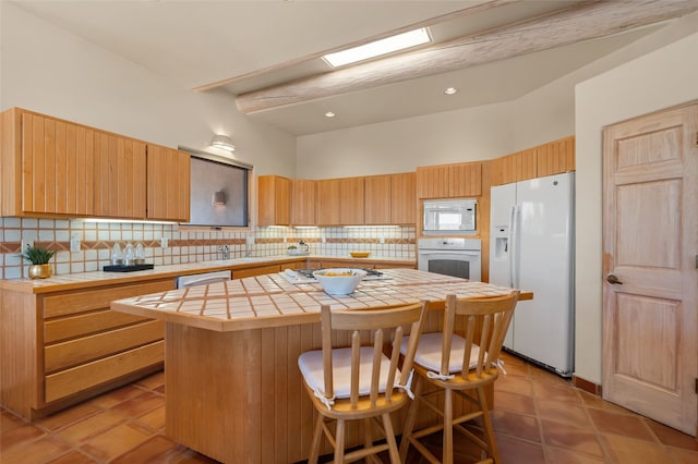 28 Camino Caballos, Lamy, NM 87540 - kitchen with white appliances, tile countertops, a kitchen island, and tasteful backsplash