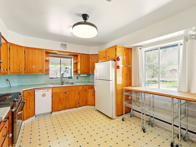 707 Middle San Pedro Rd, Espanola, NM 87532 - kitchen with white appliances, a sink, open shelves, light floors, and brown cabinets