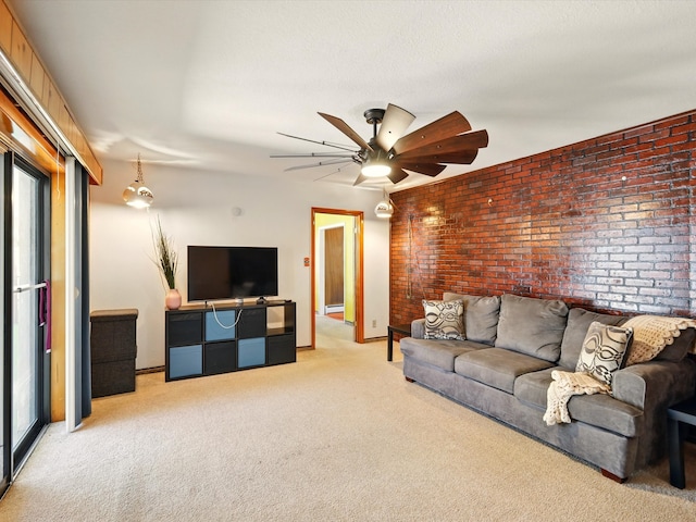 707 Middle San Pedro Rd, Espanola, NM 87532 - living room with light colored carpet, brick wall, a ceiling fan, baseboards, and a baseboard radiator