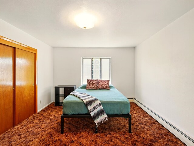 707 Middle San Pedro Rd, Espanola, NM 87532 - bedroom featuring a baseboard heating unit, carpet floors, a closet, and baseboards