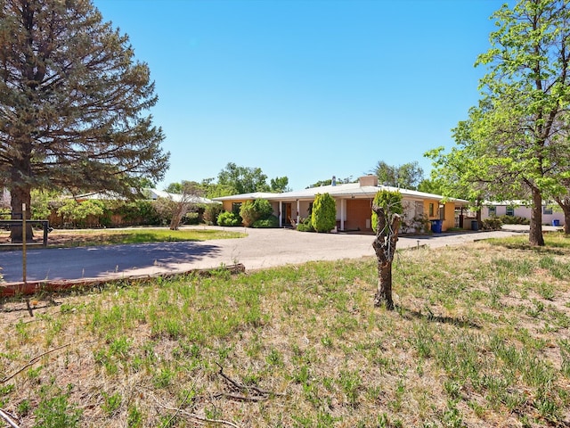 707 Middle San Pedro Rd, Espanola, NM 87532 - view of front of house featuring curved driveway and a chimney