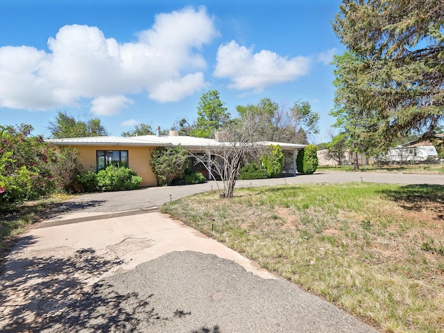 707 Middle San Pedro Rd, Espanola, NM 87532 - view of front of property with stucco siding and a chimney