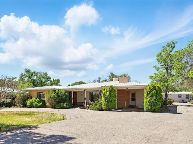 707 Middle San Pedro Rd, Espanola, NM 87532 - ranch-style house featuring a carport, a chimney, driveway, and metal roof