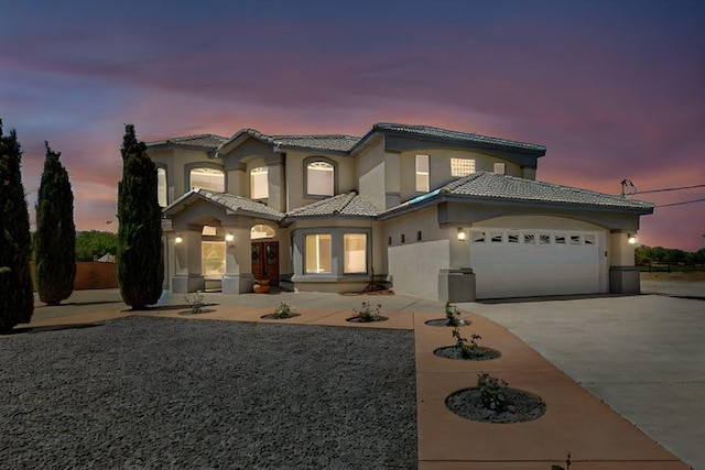 1521 Lakeview Rd SW, Albuquerque, NM 87105 - mediterranean / spanish-style house with a garage, a tile roof, concrete driveway, and stucco siding