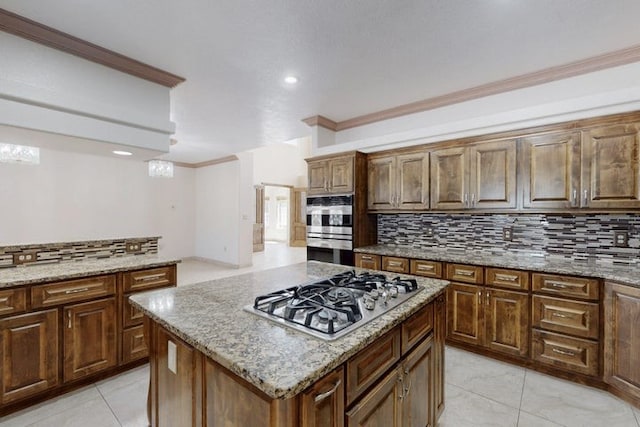 1521 Lakeview Rd SW, Albuquerque, NM 87105 - kitchen featuring stainless steel appliances, decorative backsplash, light tile patterned floors, a kitchen island, and crown molding