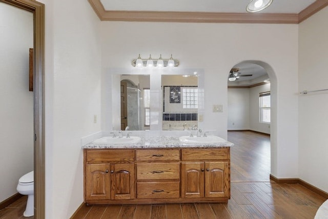 1521 Lakeview Rd SW, Albuquerque, NM 87105 - full bath featuring ornamental molding, wood finished floors, double vanity, toilet, and a ceiling fan