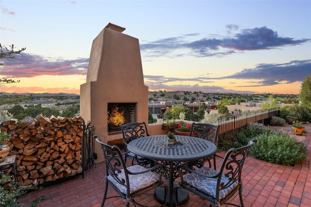 14 Avenida Sebastian, Santa Fe, NM 87506 - view of patio featuring exterior fireplace and outdoor dining space