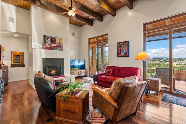 14 Avenida Sebastian, Santa Fe, NM 87506 - living area with wooden ceiling with exposed beams, hardwood / wood-style floors, ceiling fan, a warm lit fireplace, and a towering ceiling