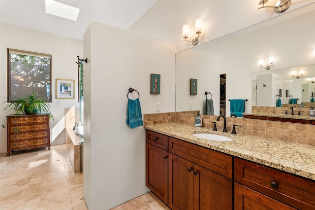 14 Avenida Sebastian, Santa Fe, NM 87506 - bathroom with decorative backsplash, vanity, a skylight, and tile patterned flooring