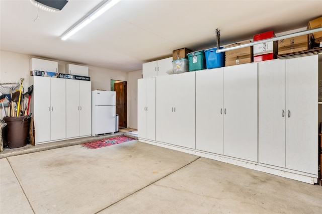 14 Avenida Sebastian, Santa Fe, NM 87506 - garage with freestanding refrigerator and a garage door opener