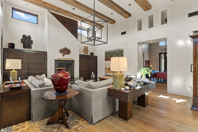 20 Rising Moon, Santa Fe, NM 87506 - living area featuring a towering ceiling, light wood finished floors, beam ceiling, and a chandelier