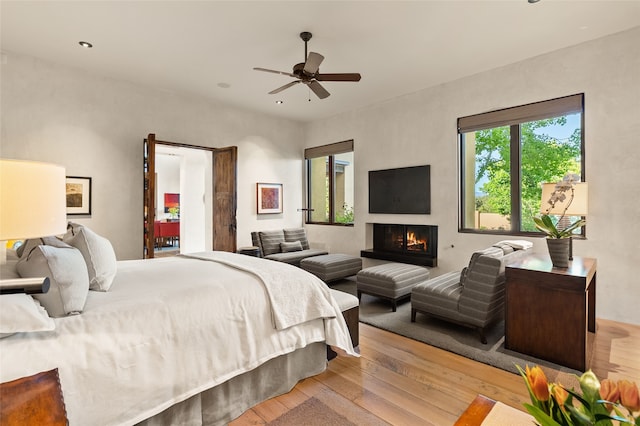 20 Rising Moon, Santa Fe, NM 87506 - bedroom with wood-type flooring, a warm lit fireplace, recessed lighting, and a ceiling fan