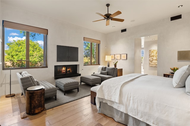 20 Rising Moon, Santa Fe, NM 87506 - bedroom featuring wood-type flooring, a warm lit fireplace, recessed lighting, and a ceiling fan