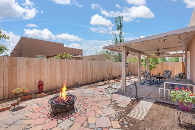 5910 Monte Rosa St, Santa Fe, NM 87507 - fenced backyard with an outdoor fire pit, a patio area, and a ceiling fan