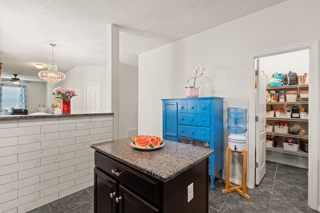 5910 Monte Rosa St, Santa Fe, NM 87507 - kitchen with dark tile patterned floors, ceiling fan, a kitchen island, decorative light fixtures, and a textured ceiling