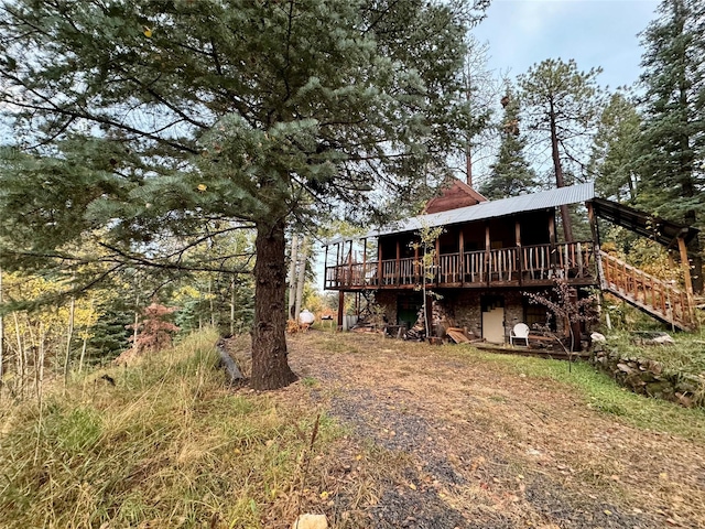 7 W Meadow Ln, Sapello, NM 87745 - rear view of house featuring a wooden deck, stairs, and stone siding