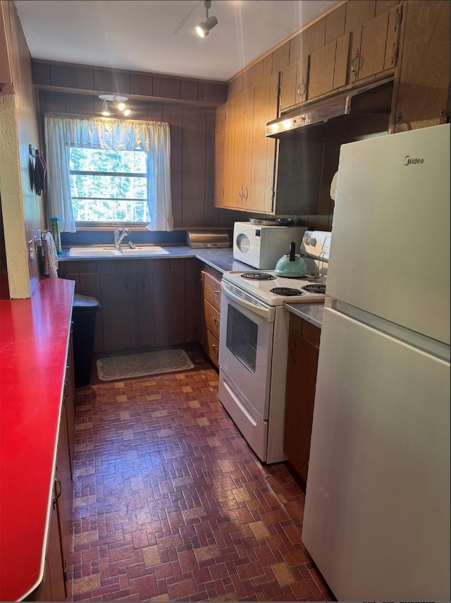 7 W Meadow Ln, Sapello, NM 87745 - kitchen featuring white appliances, under cabinet range hood, and brick patterned flooring