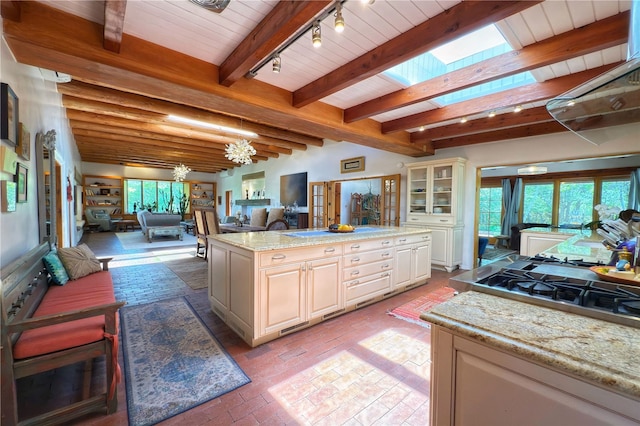 559 Camino Del Monte Sol, Santa Fe, NM 87505 - kitchen with open floor plan, brick flooring, wood ceiling with exposed beams, track lighting, and gas cooktop