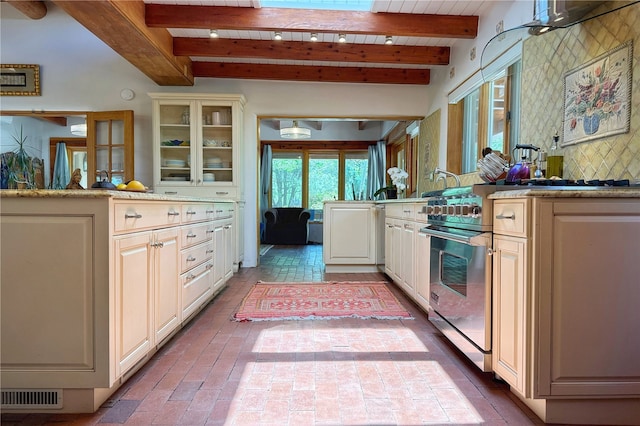 559 Camino Del Monte Sol, Santa Fe, NM 87505 - kitchen with brick floors, glass insert cabinets, wooden ceiling with exposed beams, and light countertops