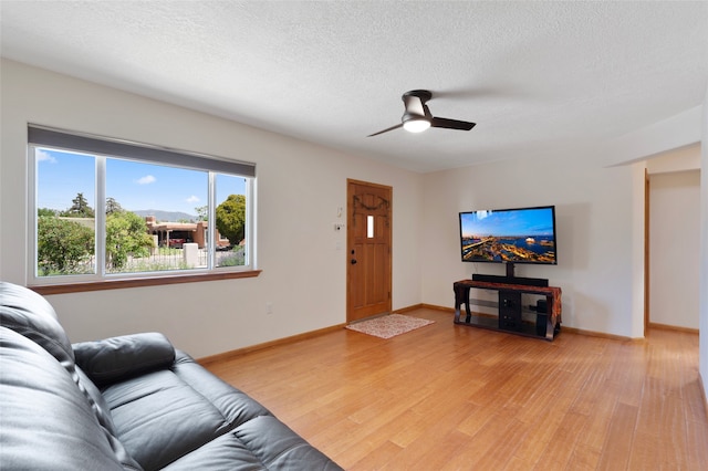 1208 Declovina St, Santa Fe, NM 87505 - living room featuring light wood-style flooring, a textured ceiling, ceiling fan, and baseboards