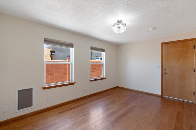 1208 Declovina St, Santa Fe, NM 87505 - spare room with wood finished floors, baseboards, a textured ceiling, and a smoke detector