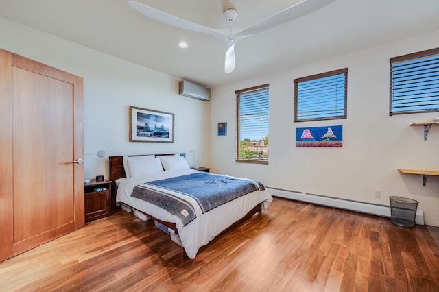 543 Juanita Unit B, Santa Fe, NM 87501 - bedroom with a wall mounted air conditioner, light wood-style floors, baseboard heating, and recessed lighting
