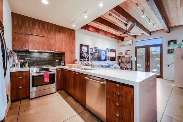 543 Juanita Unit B, Santa Fe, NM 87501 - kitchen featuring appliances with stainless steel finishes, a peninsula, a wall mounted AC, track lighting, and wood ceiling with exposed beams