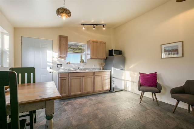 301 Camino De Las Huertas, Placitas, NM 87043 - kitchen featuring freestanding refrigerator, stainless steel microwave, vaulted ceiling, light countertops, and a sink