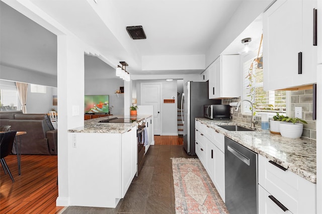 3177 Nickel Unit A, Los Alamos, NM 87544 - kitchen with stainless steel appliances, a sink, light stone countertops, white cabinetry, and backsplash