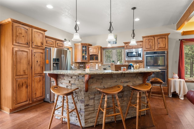 50 Jackson Hole Rd, Angel Fire, NM 87710 - kitchen featuring appliances with stainless steel finishes, decorative backsplash, glass insert cabinets, a breakfast bar, and recessed lighting