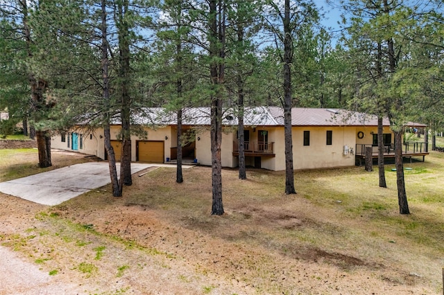 50 Jackson Hole Rd, Angel Fire, NM 87710 - ranch-style home featuring driveway, stucco siding, an attached garage, metal roof, and a front lawn
