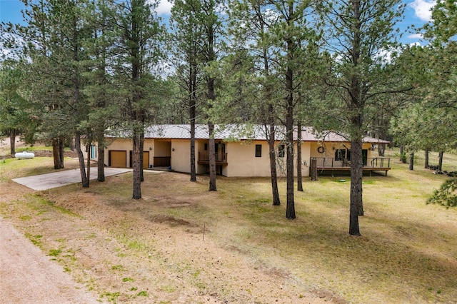 50 Jackson Hole Rd, Angel Fire, NM 87710 - view of front of house with concrete driveway, stucco siding, an attached garage, and a front yard