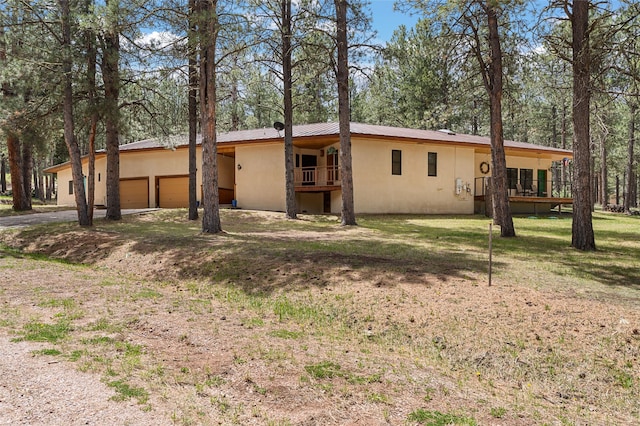 50 Jackson Hole Rd, Angel Fire, NM 87710 - view of front of house featuring stucco siding, an attached garage, metal roof, and a deck