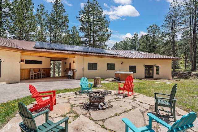 50 Jackson Hole Rd, Angel Fire, NM 87710 - back of house with a hot tub, a fire pit, french doors, a patio area, and stucco siding
