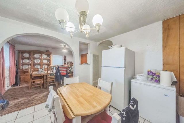 1619 Brae St, Santa Fe, NM 87505 - dining room featuring arched walkways, light tile patterned flooring, a chandelier, a textured ceiling, and light colored carpet