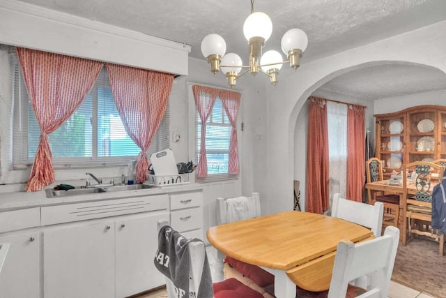 1619 Brae St, Santa Fe, NM 87505 - dining area featuring arched walkways, a chandelier, plenty of natural light, and a textured ceiling