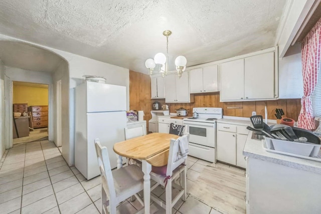 1619 Brae St, Santa Fe, NM 87505 - kitchen with white appliances, light countertops, light tile patterned flooring, white cabinetry, and a chandelier