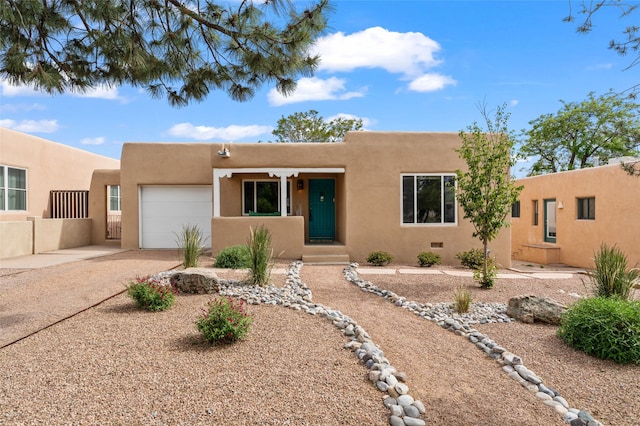 309 Lomita St, Santa Fe, NM 87505 - pueblo revival-style home featuring a garage, driveway, and stucco siding