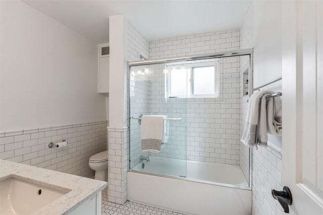 309 Lomita St, Santa Fe, NM 87505 - full bath featuring tile walls, vanity, toilet, enclosed tub / shower combo, and tile patterned floors