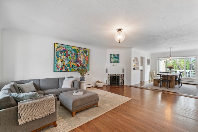 309 Lomita St, Santa Fe, NM 87505 - living area featuring wood finished floors, a textured ceiling, a baseboard heating unit, and baseboard heating