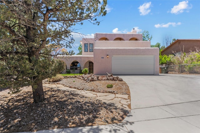 1905 Camino Redondo, Los Alamos, NM 87544 - pueblo-style home with driveway, stucco siding, an attached garage, and a chimney