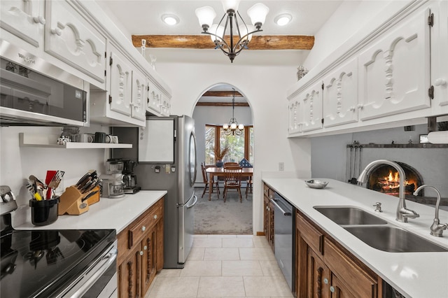 1905 Camino Redondo, Los Alamos, NM 87544 - kitchen featuring a chandelier, stainless steel appliances, a sink, arched walkways, and light carpet