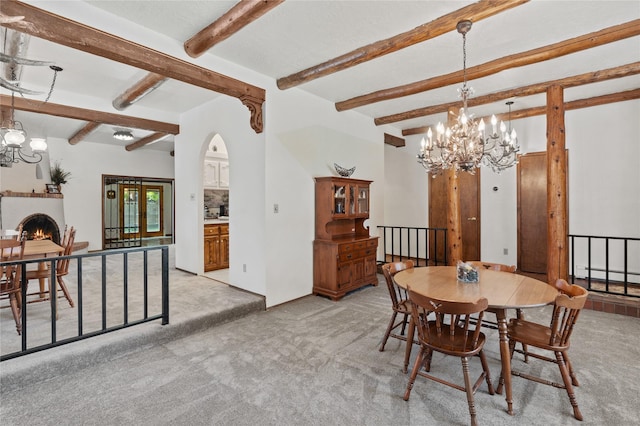 1905 Camino Redondo, Los Alamos, NM 87544 - dining area featuring a chandelier, light carpet, beam ceiling, arched walkways, and a warm lit fireplace