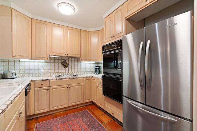 3101 Old Pecos Trl Unit 101, Santa Fe, NM 87505 - kitchen with stainless steel appliances, light brown cabinets, tasteful backsplash, tile counters, and dark tile patterned floors