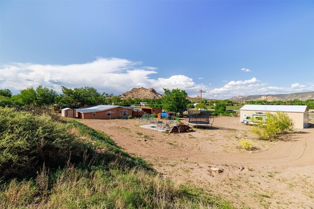 133 County Rd 135, Hernandez, NM 87537 - view of yard featuring a trampoline and a mountain view
